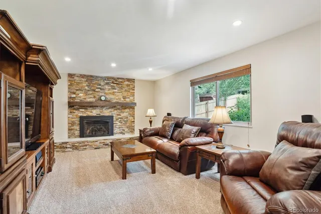 a living room with furniture a fireplace and a large window