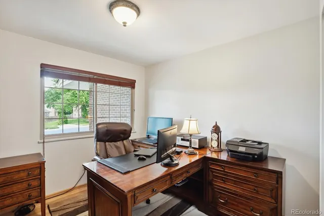 a view of a workspace with furniture and a window