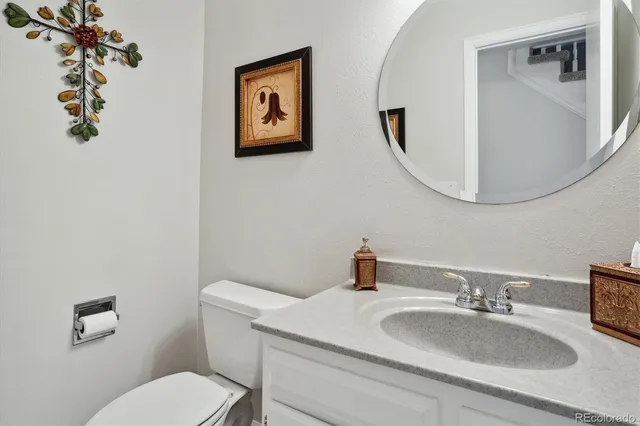 a bathroom with a toilet a sink and mirror