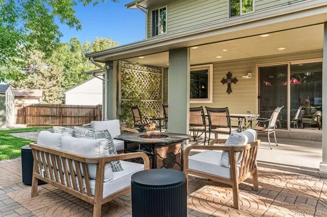a view of a patio with couches table and chairs and potted plants