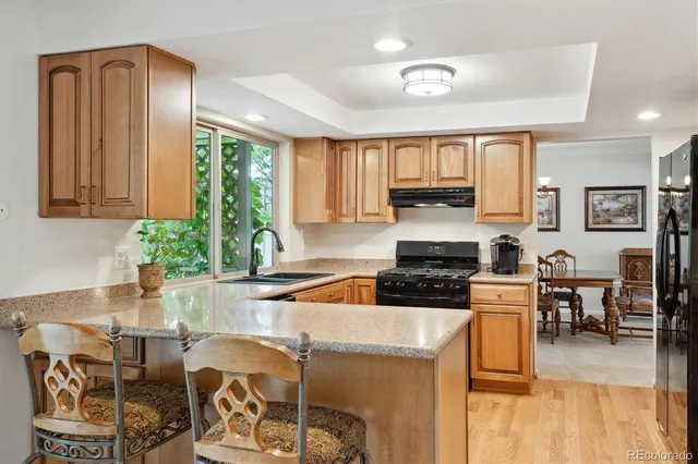 a kitchen with granite countertop a stove and white cabinets with wooden floor