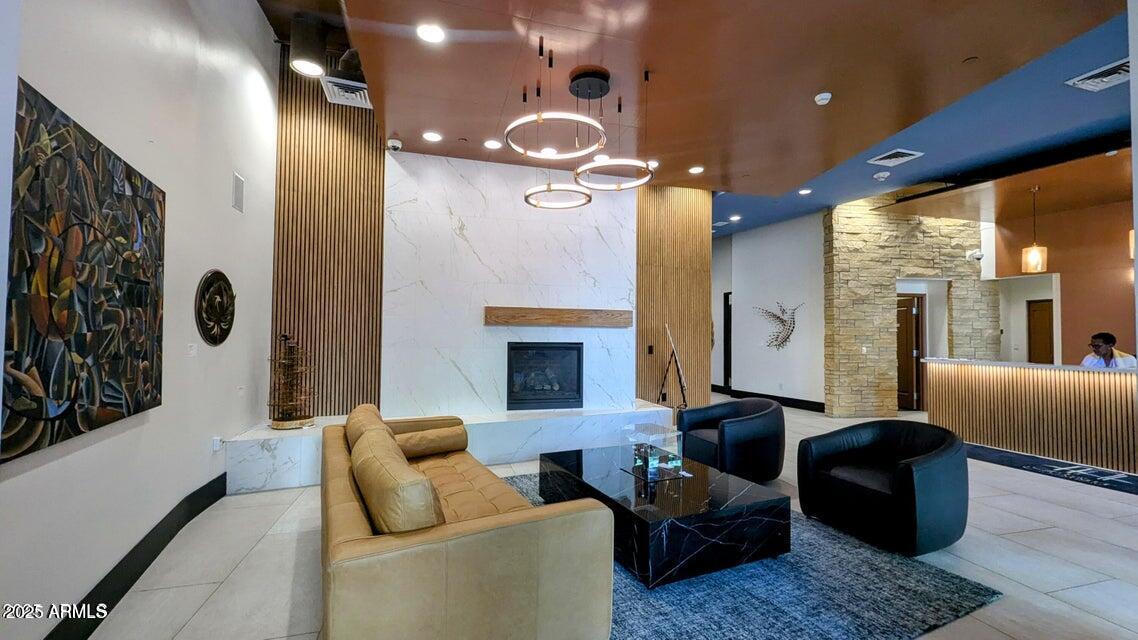 310 South 4th Street, Unit 605 Phoenix, AZ 85004 - Photo 2 of 26 a living room with furniture a fireplace and a chandelier