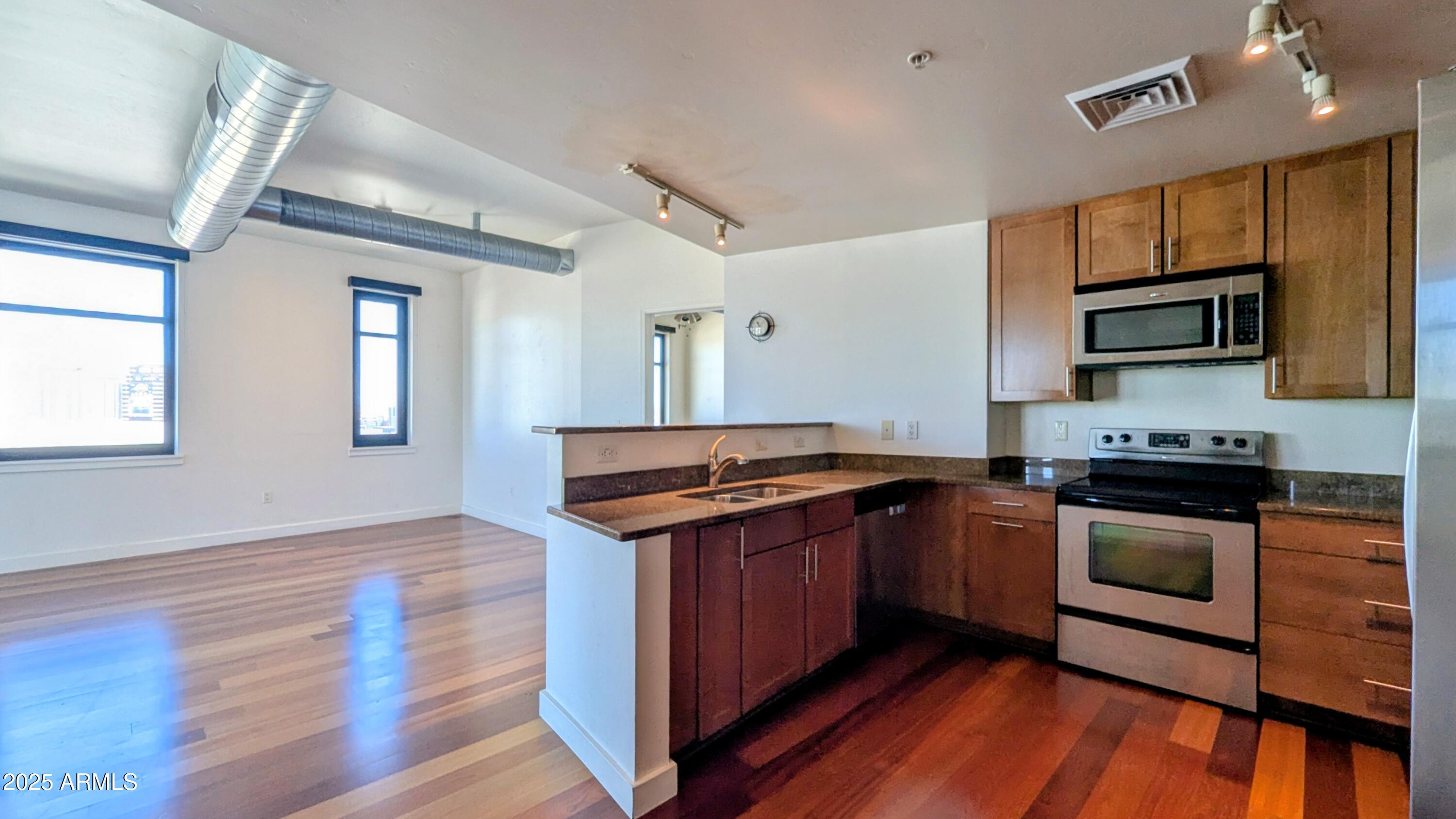 310 South 4th Street, Unit 605 Phoenix, AZ 85004 - Photo 8 of 26 a kitchen with stainless steel appliances granite countertop a stove and a sink