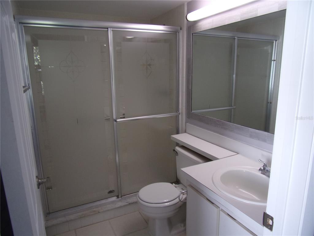 1345 Pine Ridge Circle East, Unit C2 Tarpon Springs, FL 34688 - Photo 18 of 22 a bathroom with a sink toilet and shower