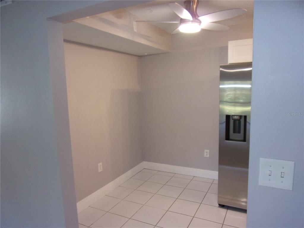 1345 Pine Ridge Circle East, Unit C2 Tarpon Springs, FL 34688 - Photo 6 of 22 a view of an empty room with window and chandelier fan