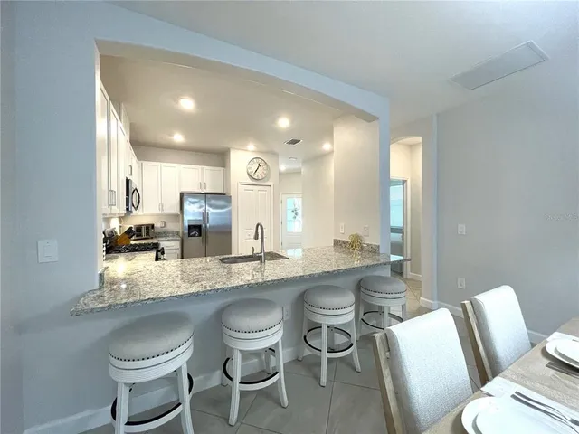 a dining area with a table chairs and a kitchen view