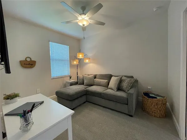 a living room with furniture a chandelier and a rug