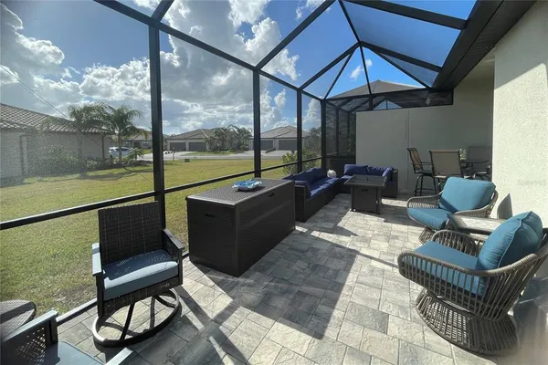 a living room with furniture a flat screen tv and a large window
