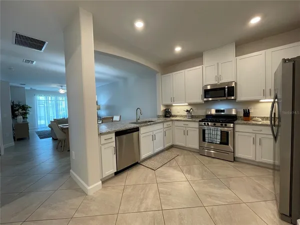a kitchen with stainless steel appliances granite countertop a stove and a microwave