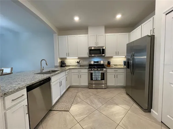 a kitchen with a dining table chairs sink and cabinets
