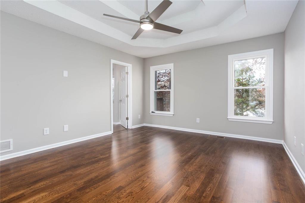 3162 Hadrian Court Powder Springs, GA 30127 - Photo 25 of 49 an empty room with wooden floor ceiling fan and windows