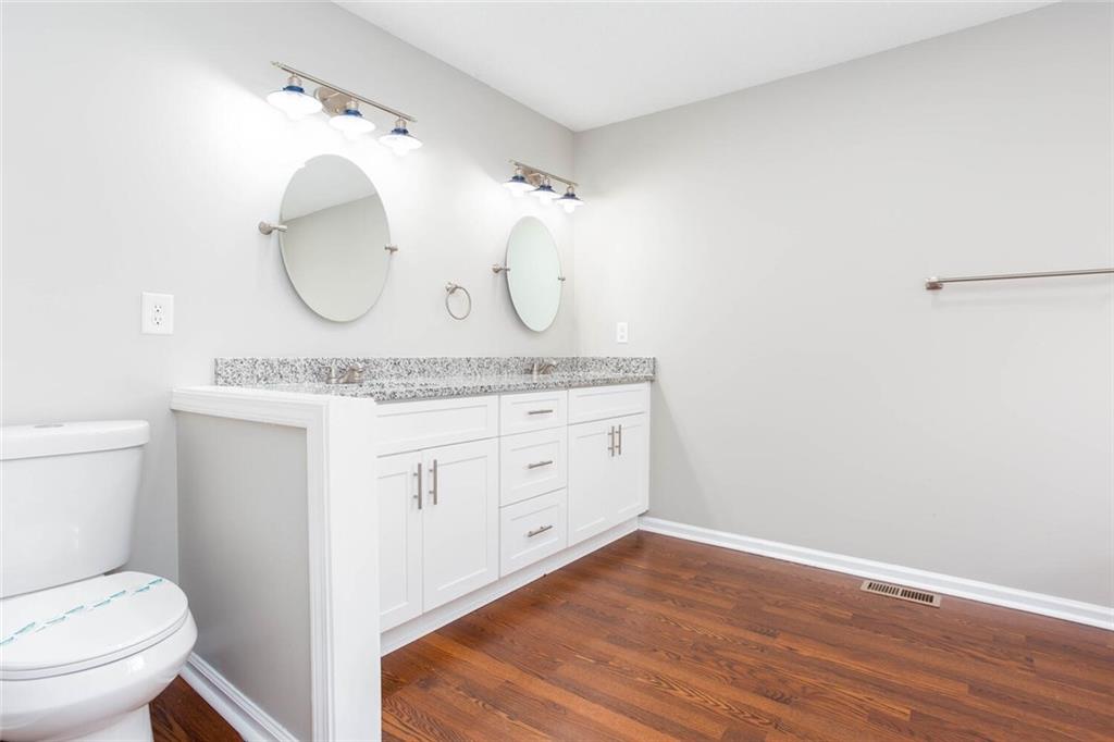 3162 Hadrian Court Powder Springs, GA 30127 - Photo 27 of 49 a spacious bathroom with a granite countertop toilet sink mirror and vanity