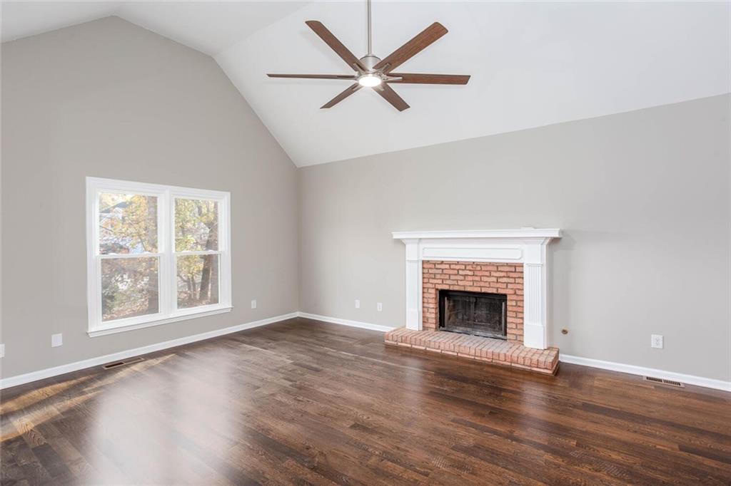3162 Hadrian Court Powder Springs, GA 30127 - Photo 5 of 49 an empty room with windows fireplace and wooden floor