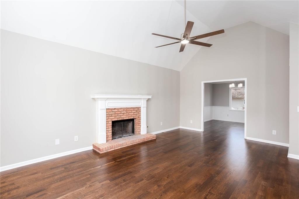 3162 Hadrian Court Powder Springs, GA 30127 - Photo 9 of 49 a view of an empty room with wooden floor and a fireplace