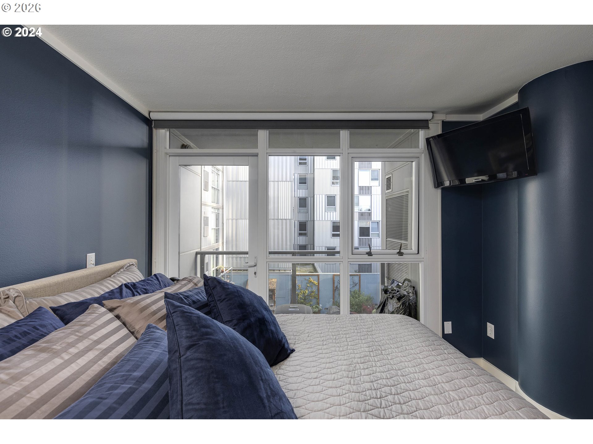 533 Northeast Holladay Street, Unit 409 Portland, OR 97232 - Photo 17 of 38 a bed room with a bed and a large window