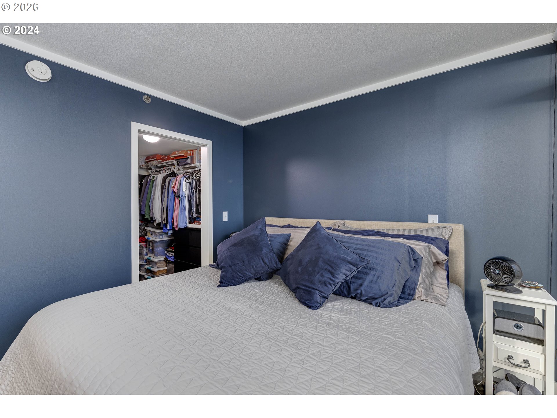 533 Northeast Holladay Street, Unit 409 Portland, OR 97232 - Photo 19 of 38 a large bed sitting in a bedroom and painting on the wall