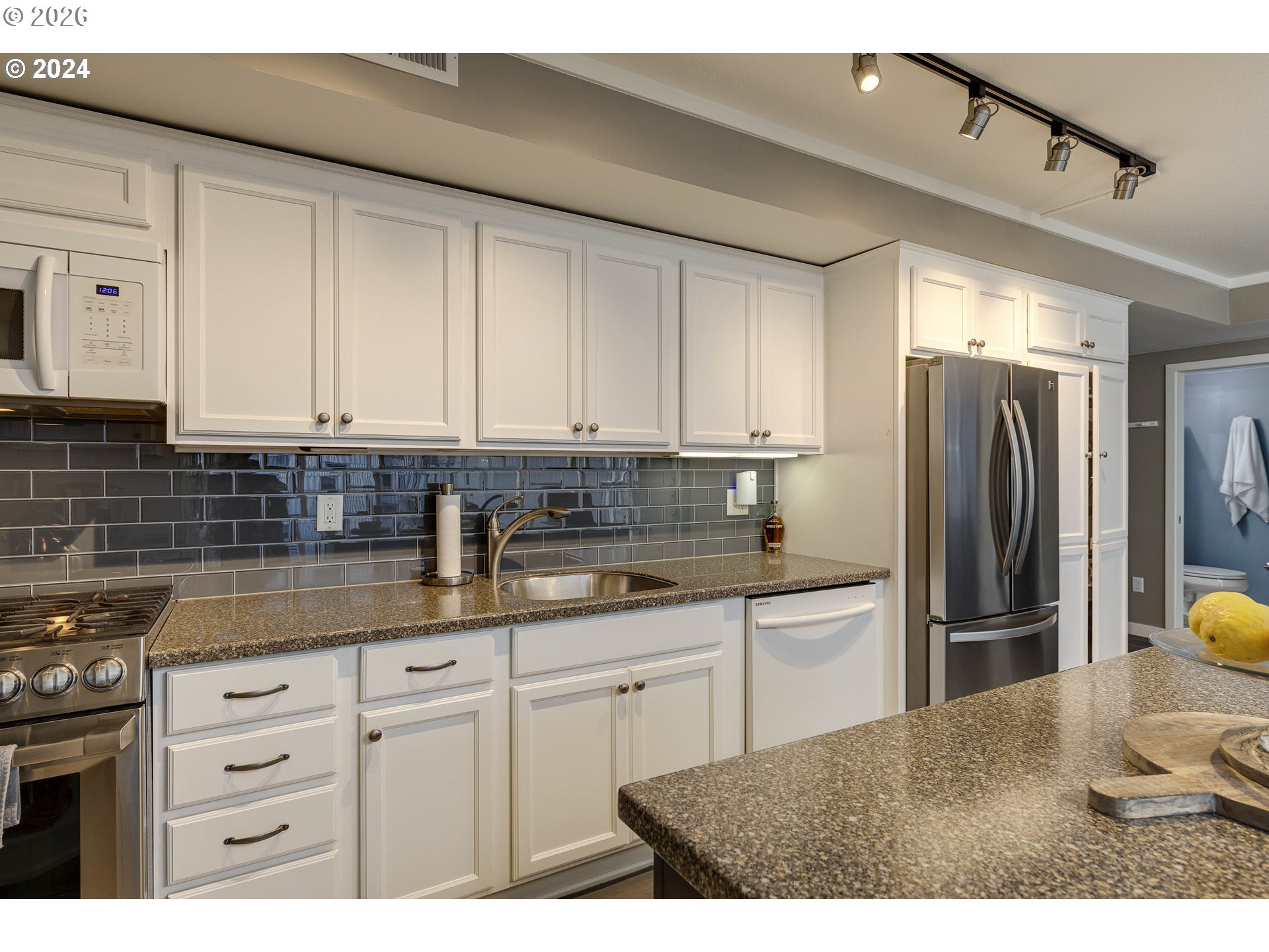 533 Northeast Holladay Street, Unit 409 Portland, OR 97232 - Photo 2 of 38 a kitchen with kitchen island a sink stainless steel appliances and cabinets
