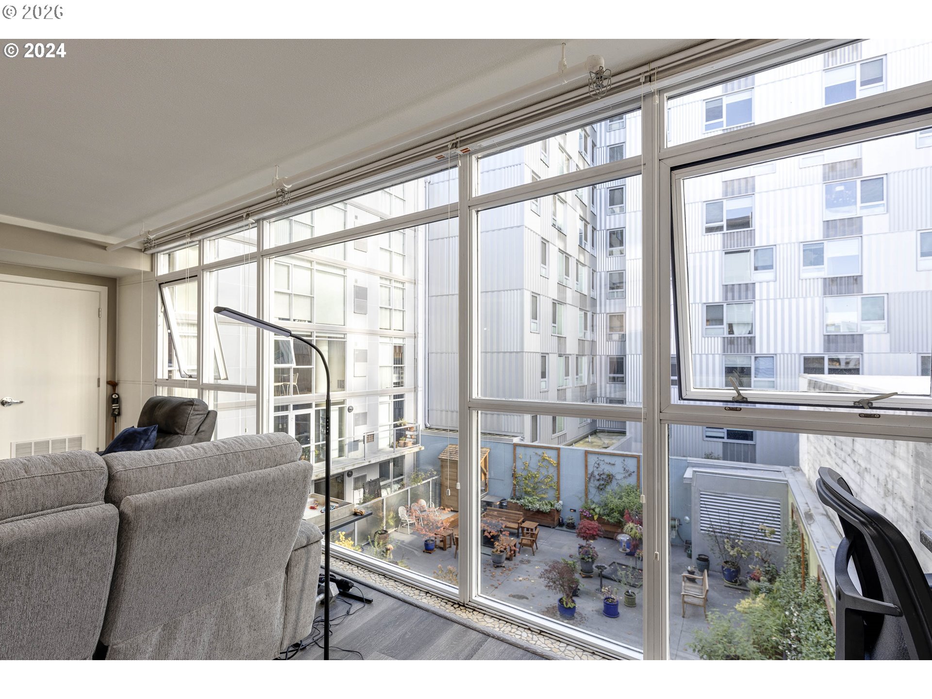 533 Northeast Holladay Street, Unit 409 Portland, OR 97232 - Photo 7 of 38 a living room filled with furniture and a floor to ceiling window