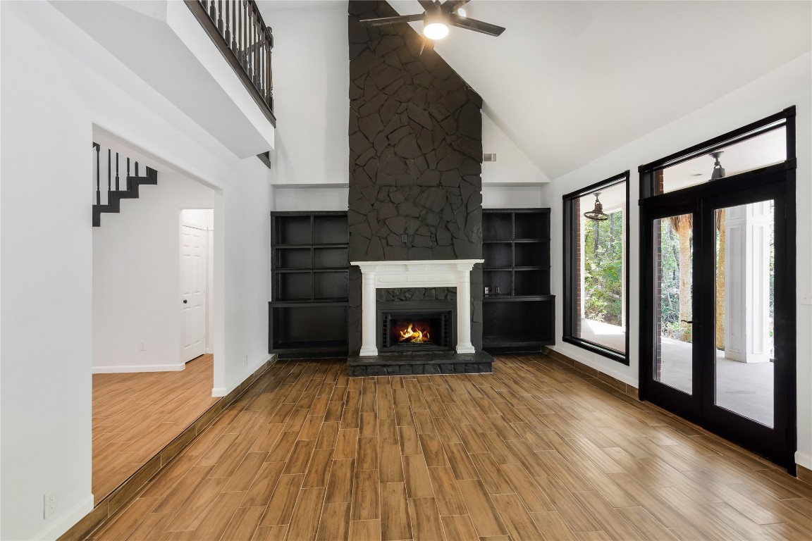 40111 Roundup Road Magnolia, TX 77354 - Photo 12 of 42 a view of an empty room with wooden floor fireplace and a window