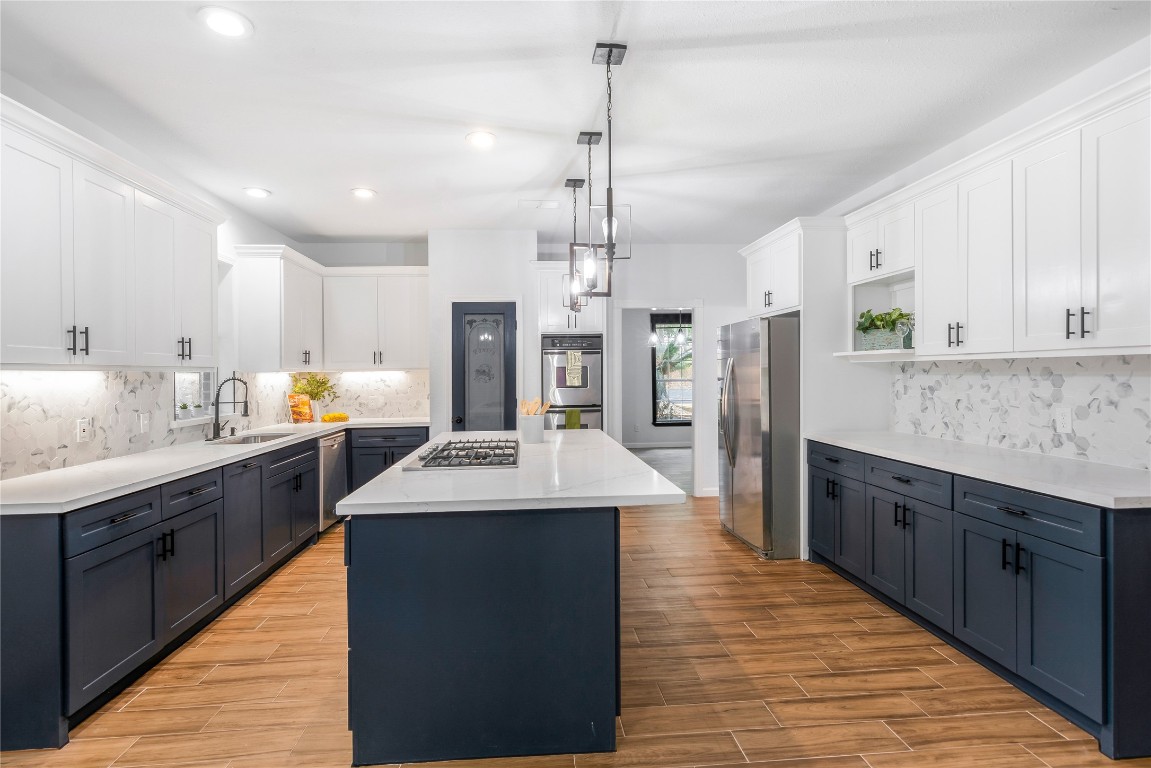 40111 Roundup Road Magnolia, TX 77354 - Photo 14 of 42 a kitchen with stainless steel appliances kitchen island granite countertop a sink stove and refrigerator