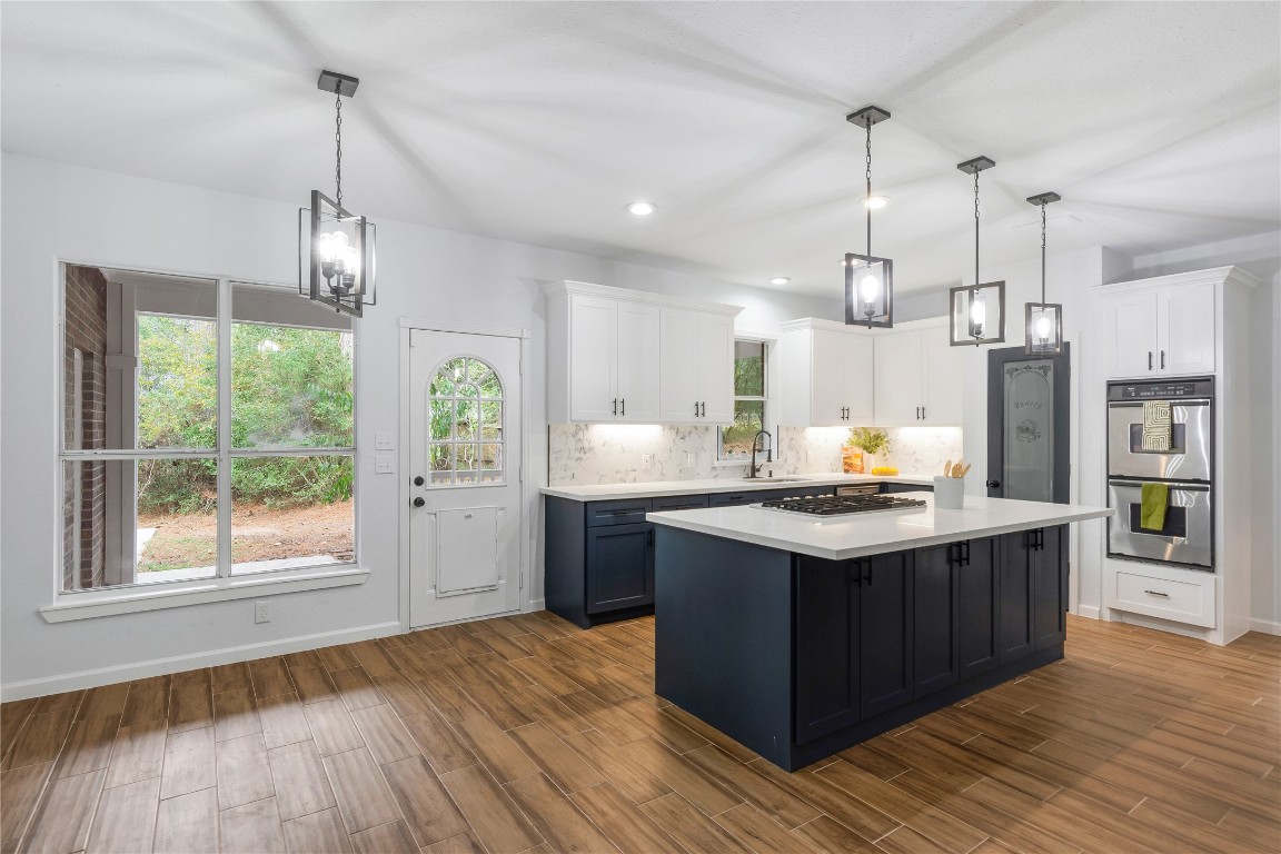 40111 Roundup Road Magnolia, TX 77354 - Photo 17 of 42 a kitchen with stainless steel appliances granite countertop a sink a stove and a wooden floors