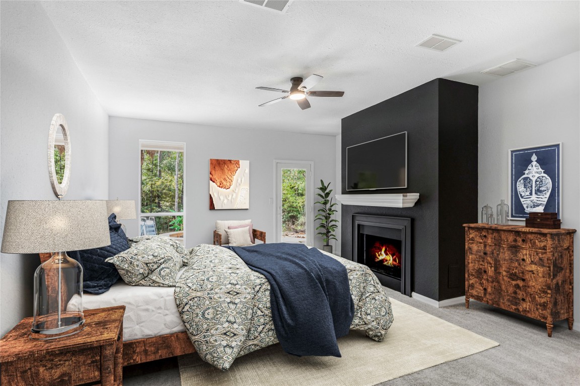 40111 Roundup Road Magnolia, TX 77354 - Photo 19 of 42 a bedroom with a bed and a fireplace