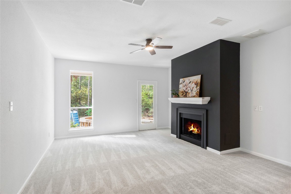 40111 Roundup Road Magnolia, TX 77354 - Photo 20 of 42 an empty room with windows fireplace and fan