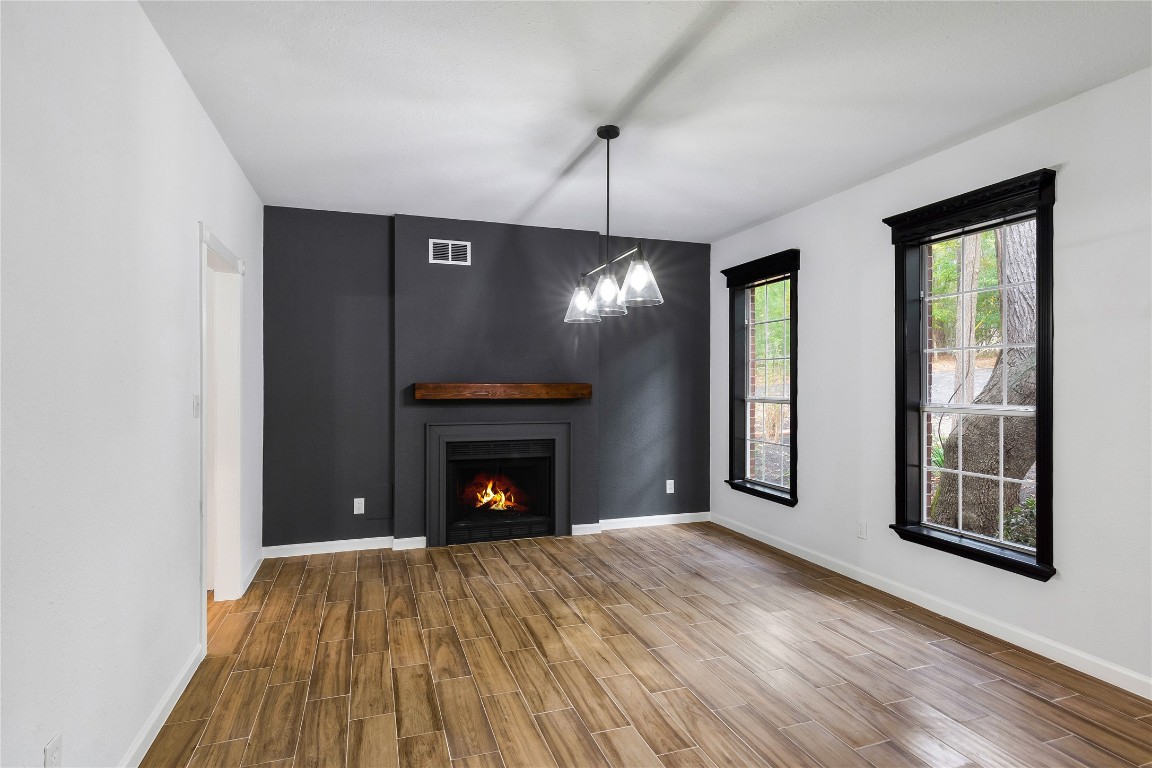 40111 Roundup Road Magnolia, TX 77354 - Photo 10 of 42 a view of an empty room with wooden floor fireplace and a window