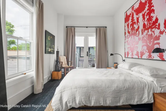 a bedroom with a bed and a painting on the wall