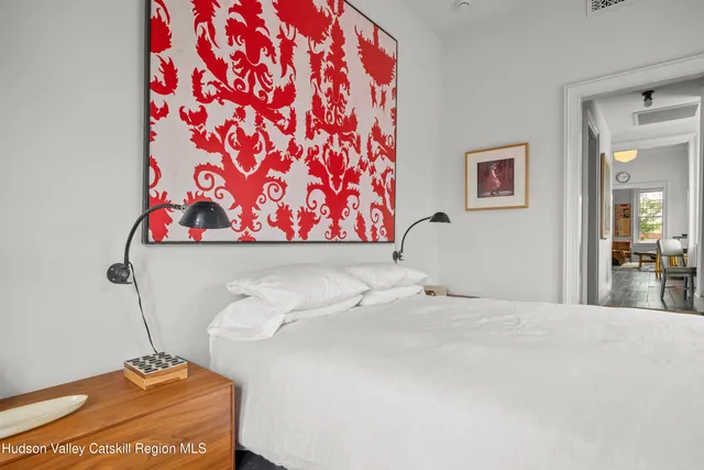 a bedroom with a bed and a painting on the wall