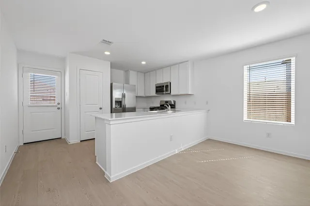 a kitchen with white cabinets and white appliances