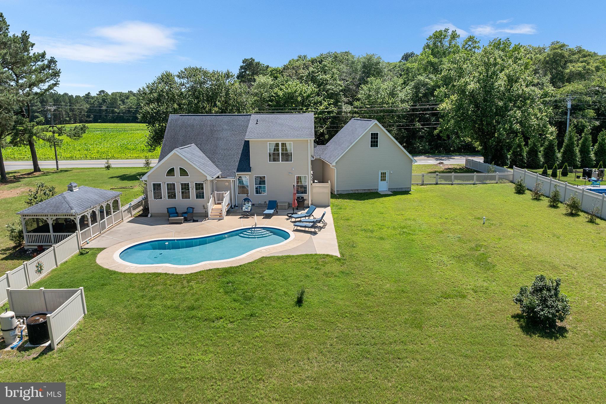 a view of a house with pool and a yard