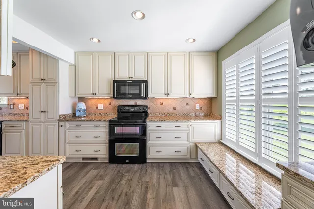a kitchen with white cabinets and appliances