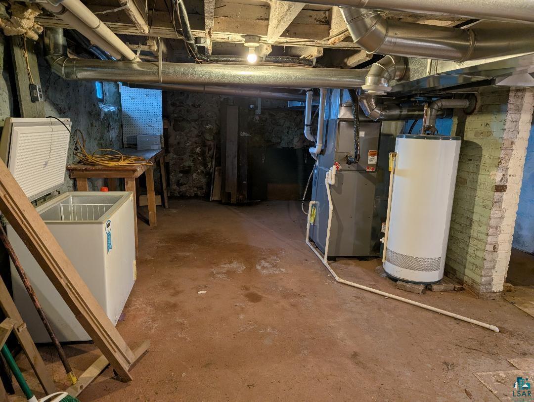 513 South Main Street Mellen, WI 54546 - Photo 22 of 22 Basement utility area featuring exposed ceiling joists, stone foundation walls, and a concrete floor