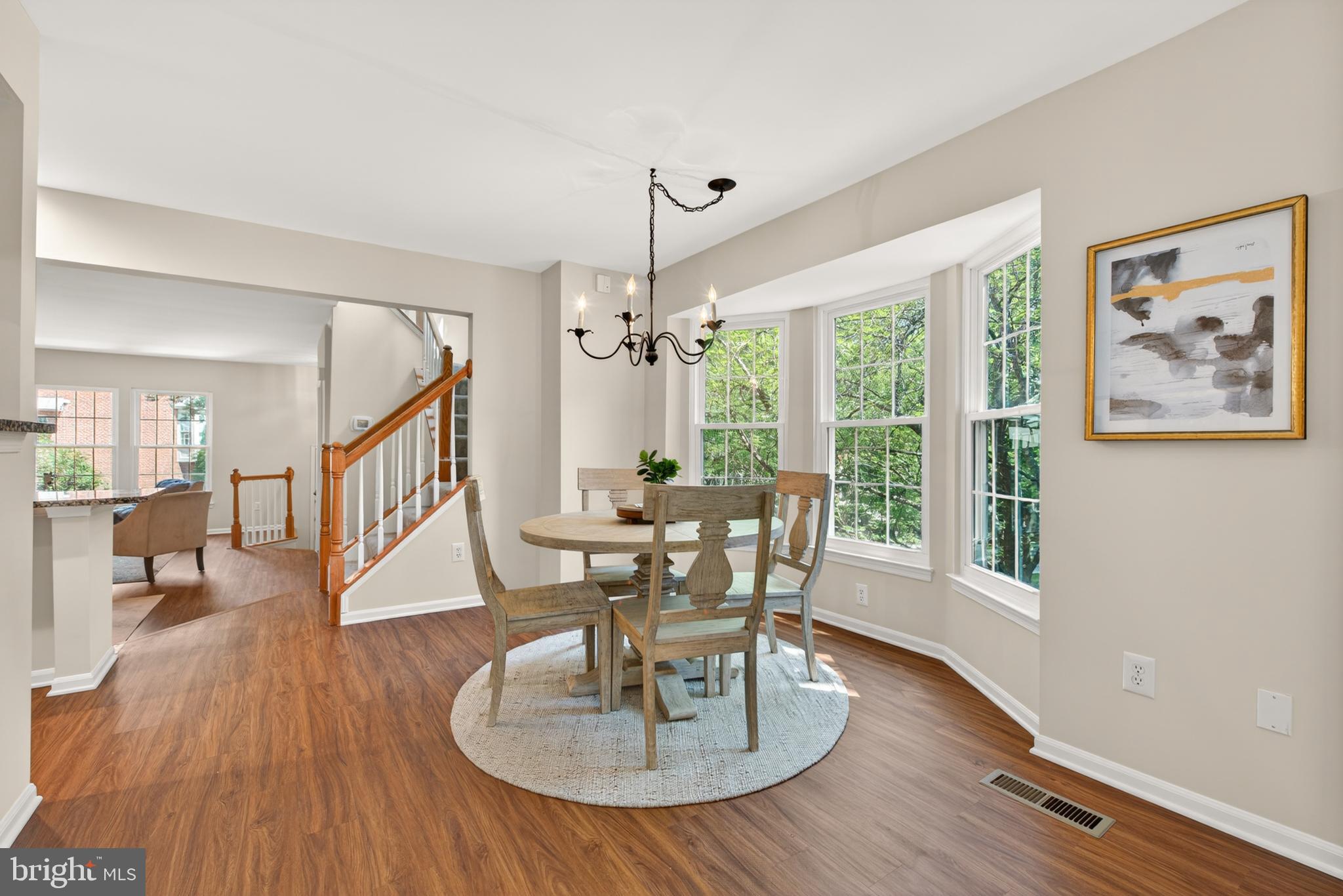 1409 Park Garden Lane Reston, VA 20194 - Photo 12 of 41 a dining room with wooden floor a chandelier a wooden table and chairs