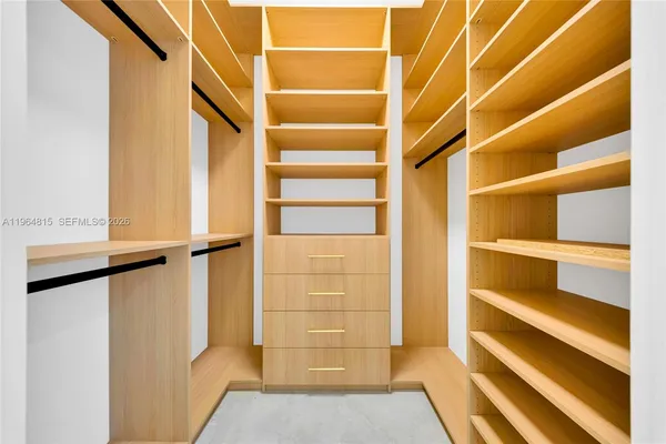 a view of walk in closet with empty racks