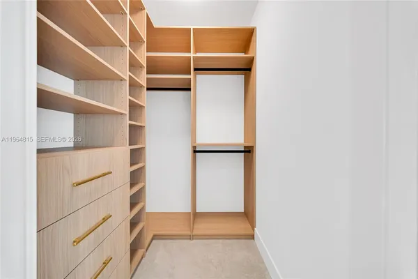 a view of walk in closet with empty racks