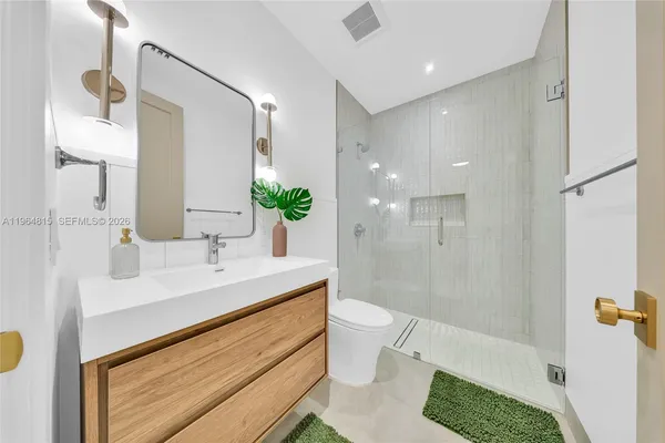 a spacious bathroom with a double vanity sink a mirror and a shower
