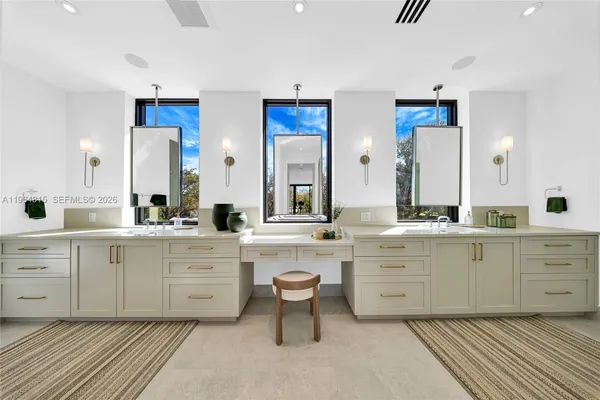 a large white kitchen with a white cabinets and chairs