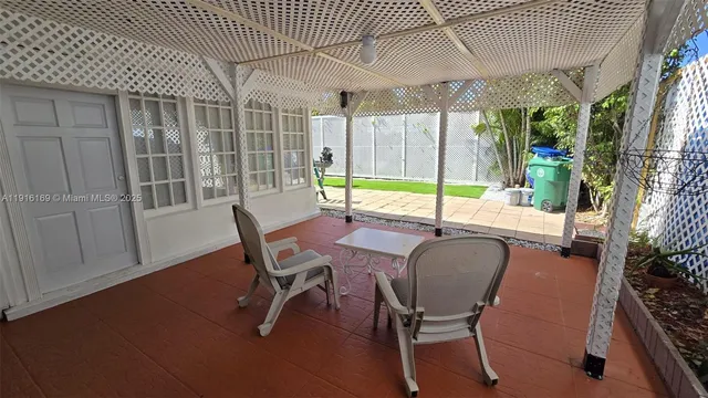 a view of a patio with table and chairs with wooden floor and fence