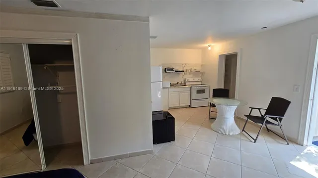 a view of a kitchen with chair and refrigerator