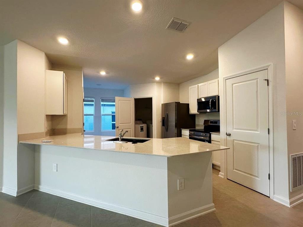 339 Puma Loop Groveland, FL 34736 - Photo 4 of 23 a large kitchen with stainless steel appliances lots of counter space and a sink