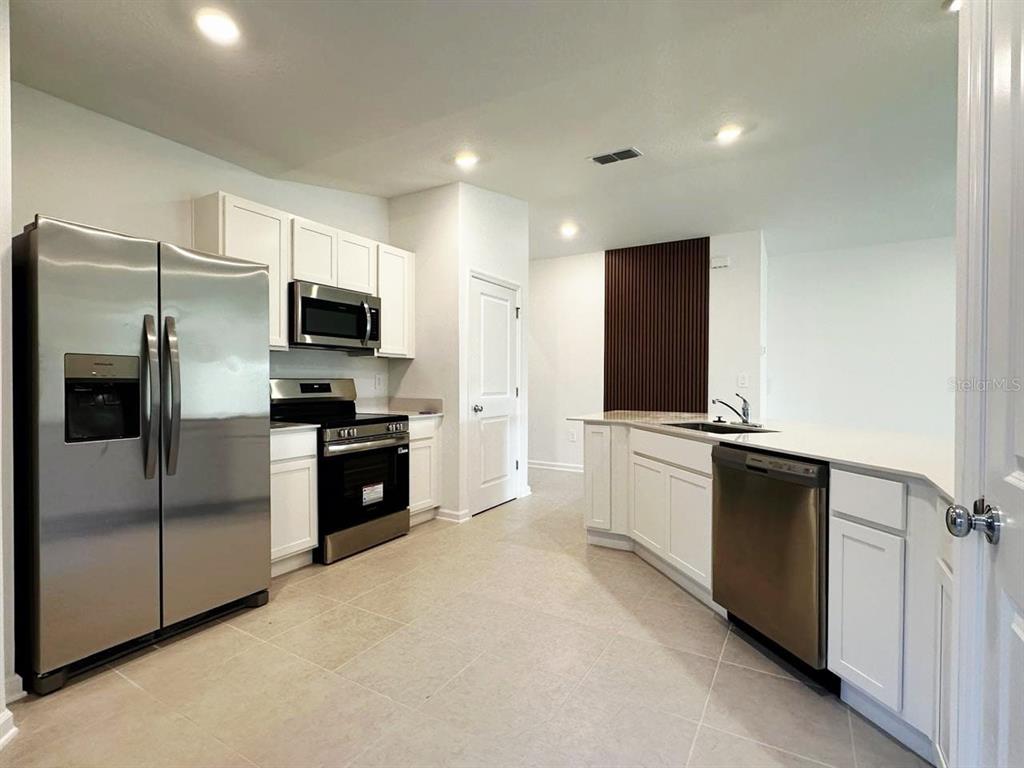 339 Puma Loop Groveland, FL 34736 - Photo 5 of 23 a large kitchen with a large window and stainless steel appliances
