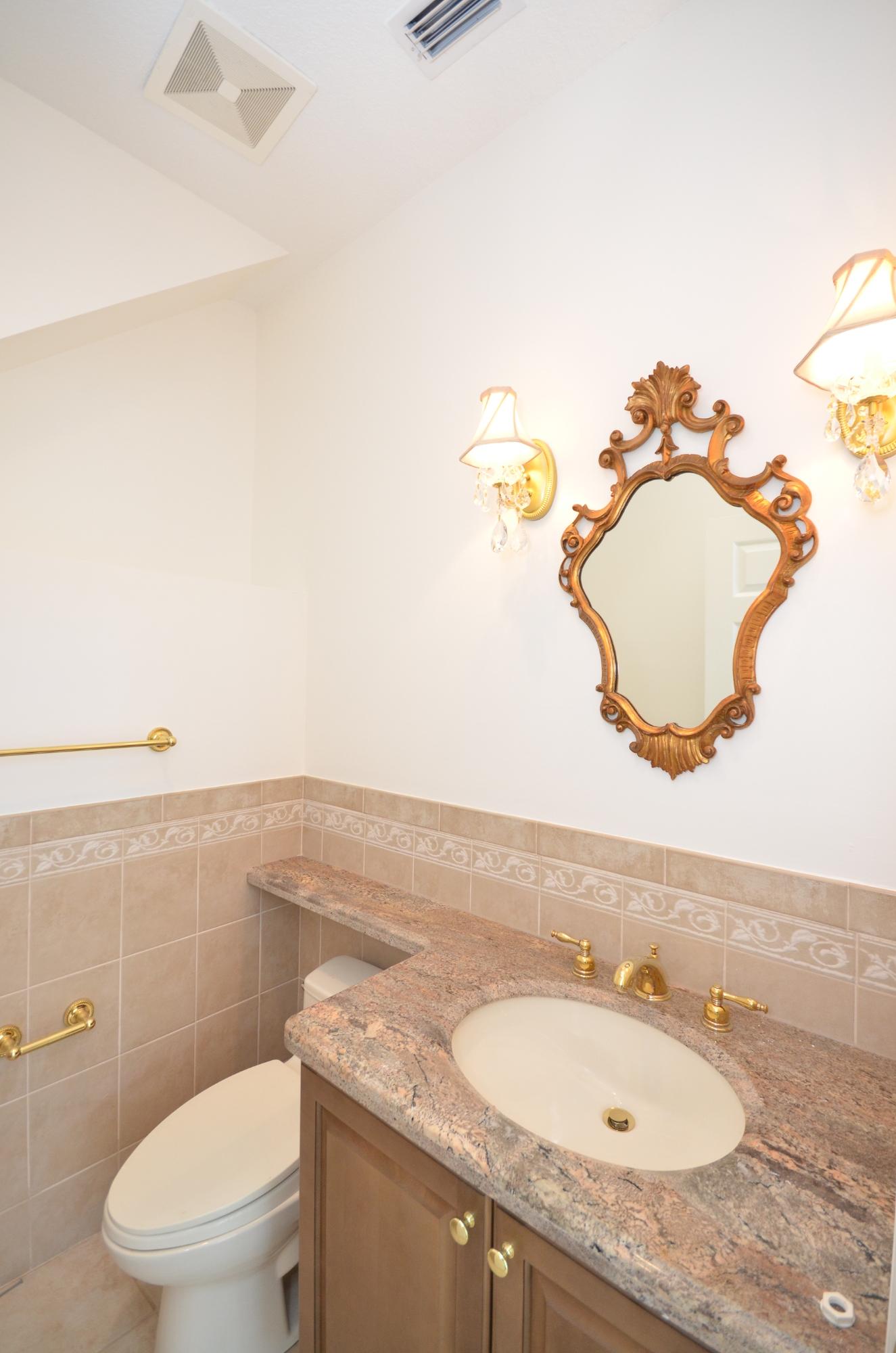 10873 Ravel Court Boca Raton, FL 33498 - Photo 16 of 18 a bathroom with a granite countertop sink and a mirror