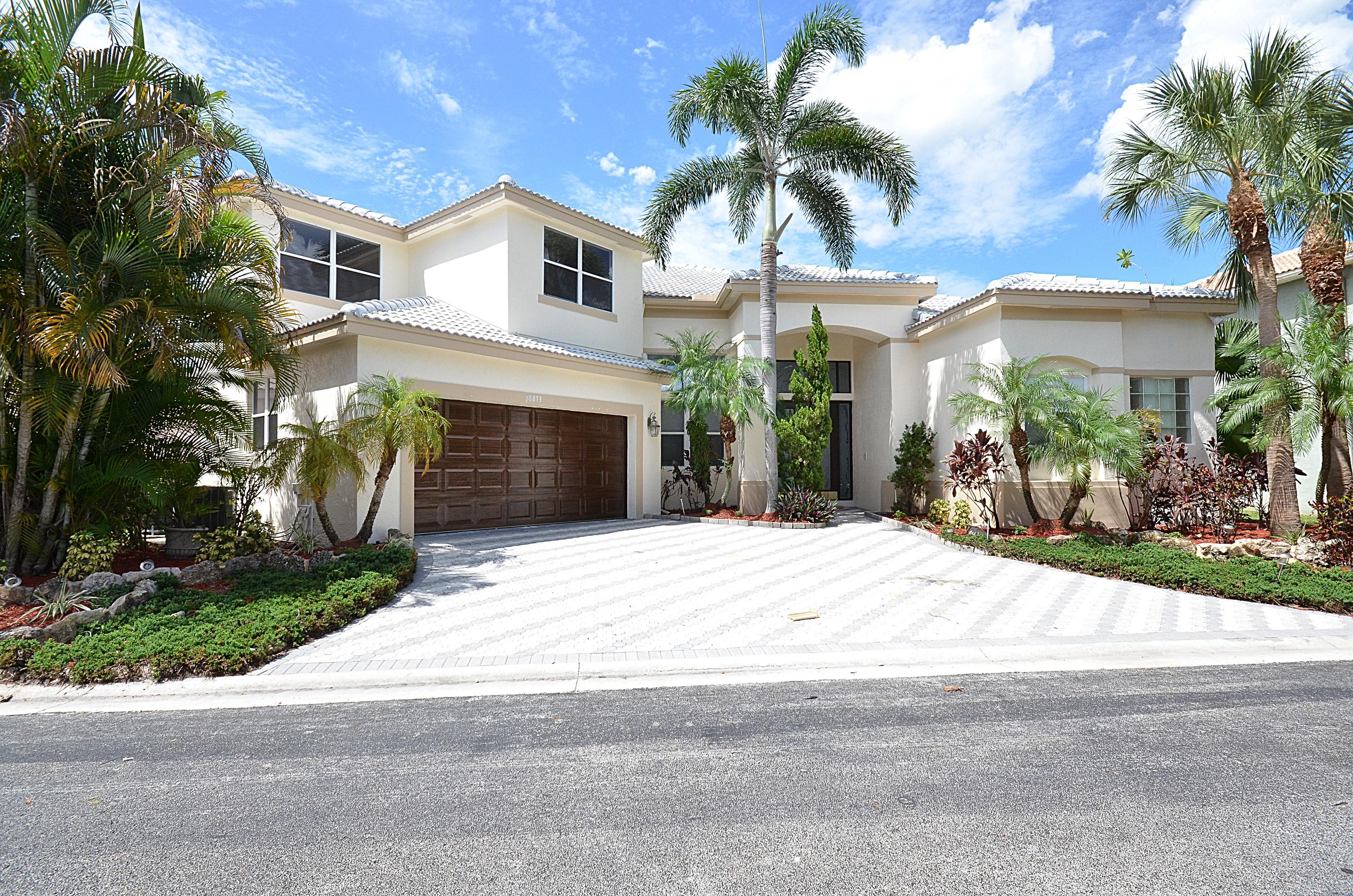 10873 Ravel Court Boca Raton, FL 33498 - Photo 2 of 18 a front view of a house with a yard and garage