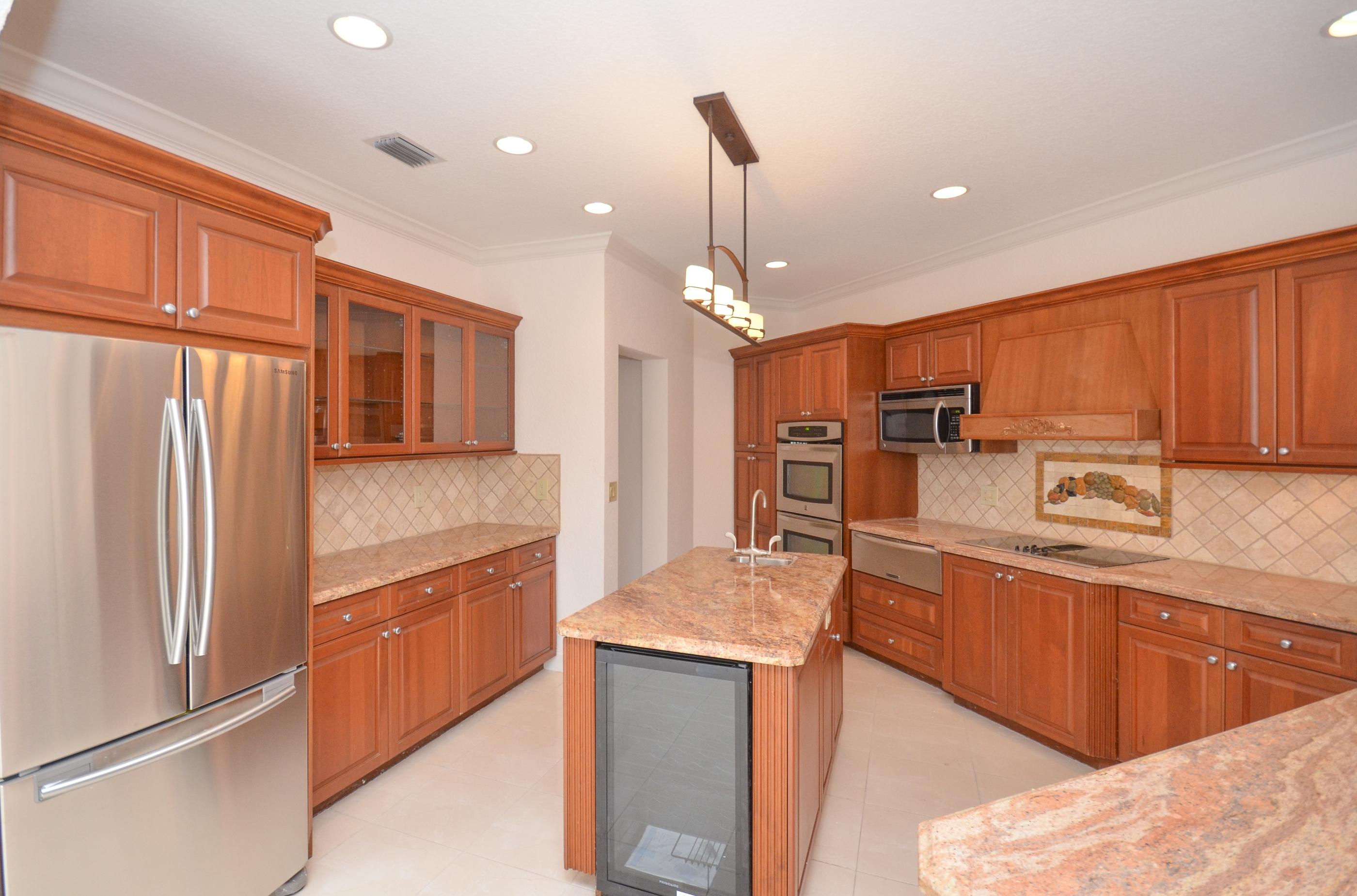 10873 Ravel Court Boca Raton, FL 33498 - Photo 5 of 18 a kitchen with stainless steel appliances granite countertop a refrigerator a sink and a stove