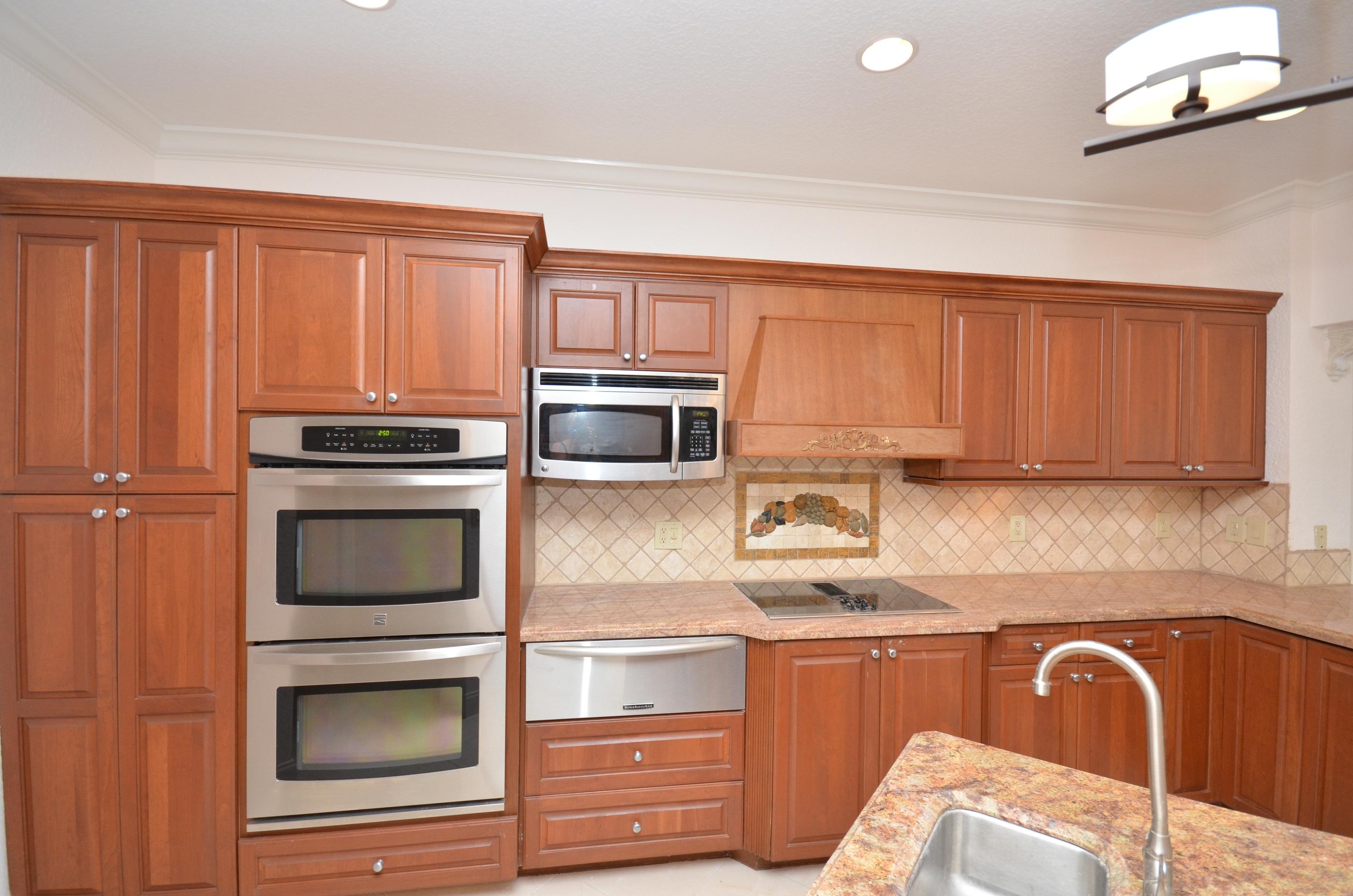 10873 Ravel Court Boca Raton, FL 33498 - Photo 6 of 18 a kitchen with stainless steel appliances granite countertop a stove microwave and refrigerator