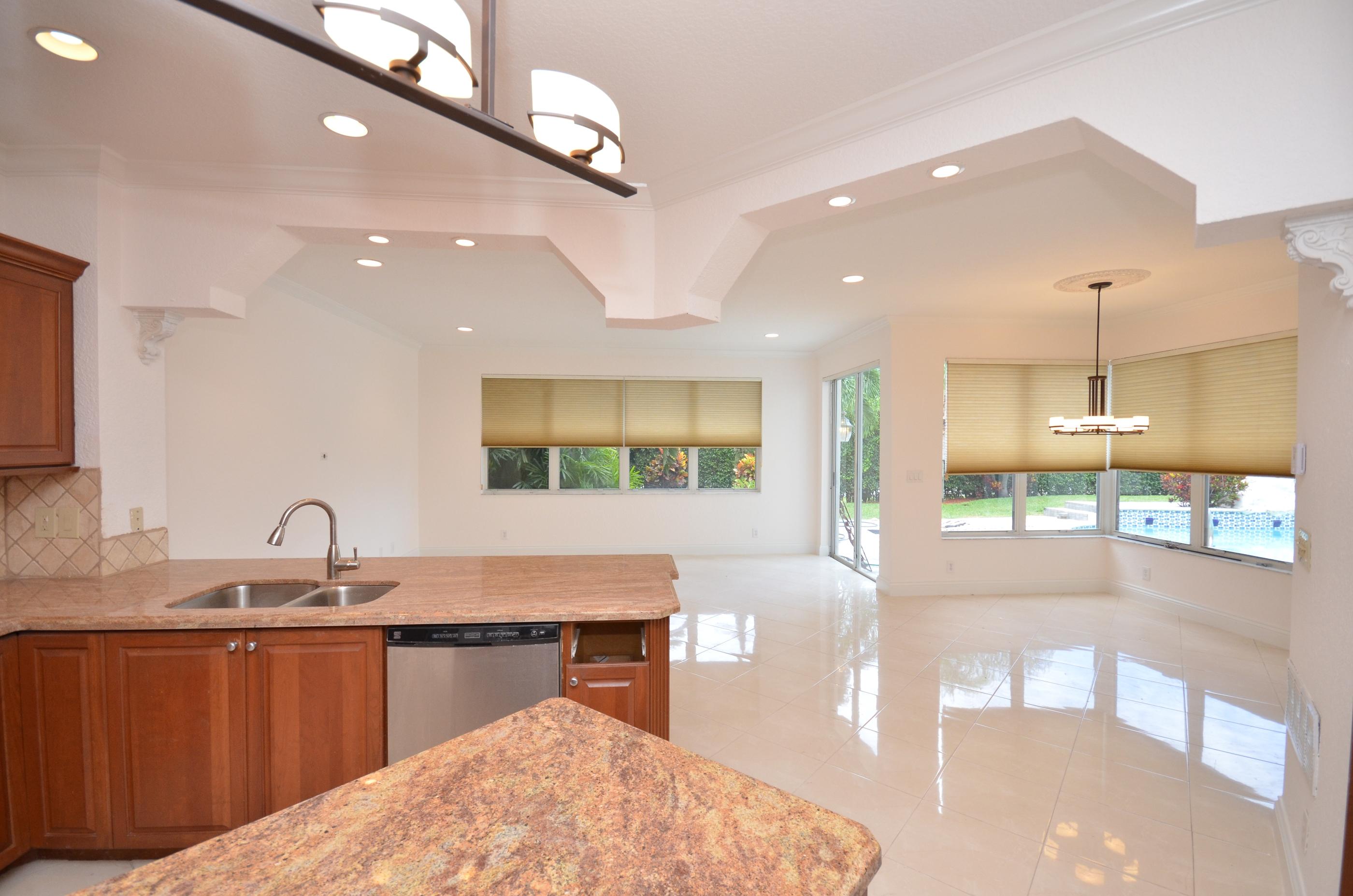 10873 Ravel Court Boca Raton, FL 33498 - Photo 8 of 18 a kitchen with stainless steel appliances kitchen island granite countertop a sink and cabinets