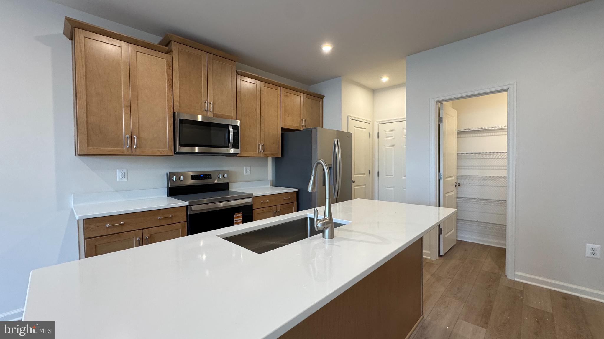 a kitchen with stainless steel appliances a microwave sink refrigerator and cabinets