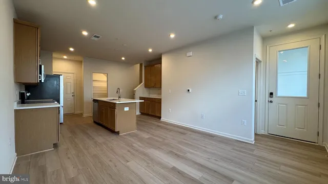 a large kitchen with a wooden floor a large window and a sink